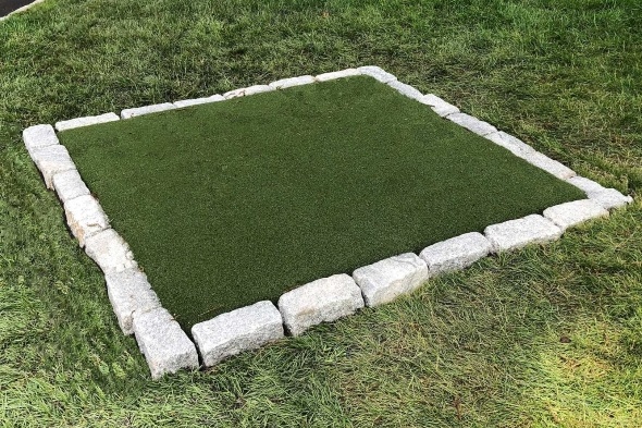 Greenwich Tee box made of synthetic grass surrounded by stone border